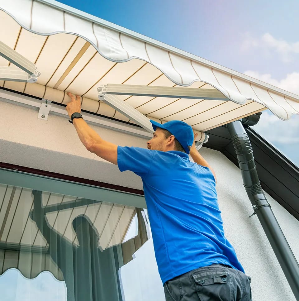 Installer working carefully near a retractable awning frame