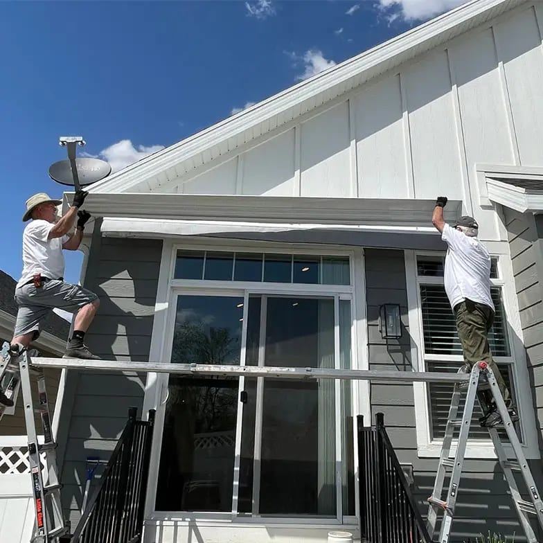 Technicians installing a retractable awning