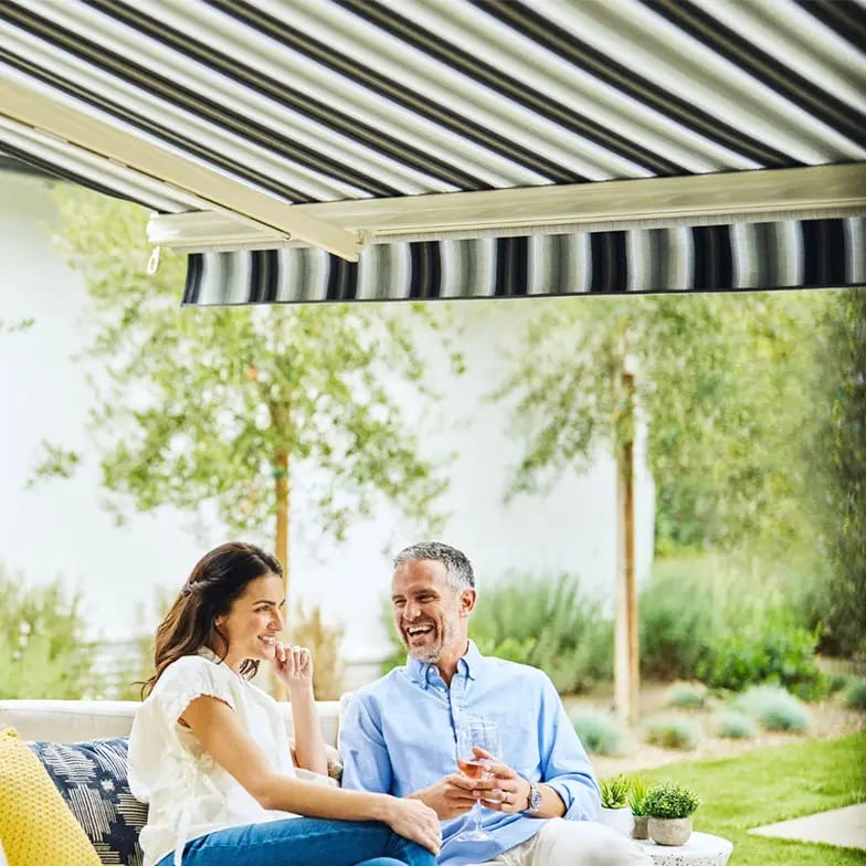 Happy couple relaxing beneath a retractable awning