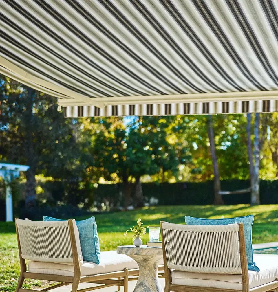 Striped retractable awning overlooking a backyard pool